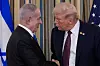 Donald Trump og Benjamin Netanyahu står tett og håndhilser foran flagg i Det hvite hus.