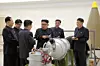 Nord-Koreas leder Kim Jong-un (i midten) med representanter for landets atomprogram. Scanpix/Reuters.