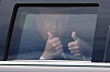 Donald Trump sitter i en mørk presidentlimousine og gir tommel opp gjennom vinduet.