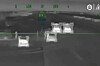 Infrarødt dronebilde med flere lyse målmarkeringer i et mørkt landskap og overlagt siktegrafikk.