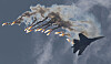 Et Su-27-jagerfly flyr ved siden av røykspor og et formasjonsteam på himmelen.