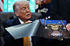 Donald Trump viser frem et bilde av et UFC-arrangement mens han sitter i Det ovale kontor.