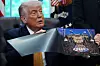 Donald Trump viser frem et bilde av et UFC-arrangement mens han sitter i Det ovale kontor.