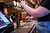 Bartender tapper en halvliter øl ved en bar i Oslo.