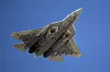 En russisk Sukhoi Su-57-jagerfly sett nedenfra mot blå himmel.