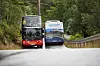 To turistbusser kjører opp en smal, svingete vei på Aksla i Ålesund.