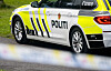 Siden av en politibil med gulhvite refleksstriper og teksten POLITI.
