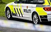 Siden av en politibil med gulhvite refleksstriper og teksten POLITI.