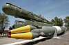 Et stort grønt russisk missil er vist utendørs sammen med flere mindre missiler foran.