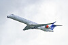 Et SAS-passasjerfly ses fra undersiden mot lys himmel under avgang.