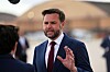 JD Vance står utendørs og snakker med reportere etter å ha gått av et fly.