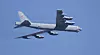 Et grått B-52-bombefly flyr mot blå himmel.