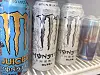 Flere bokser energidrikk står i et kjøleskap, inkludert Monster og Red Bull.