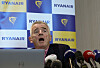 Michael O'Leary taler ved en pressekonferanse med Ryanair-logoer i bakgrunnen.