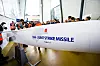 Stor modell av JSM-Joint Strike Missile vises frem for en gruppe personer i en lys industrisal.