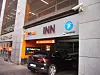 En bil kjører inn i et parkeringshus ved et skilt for Autopay.