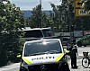 En politibil står ved veikanten mens en politibetjent og en sykkel er synlige ved et kryss.