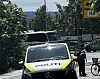En politibil står ved veikanten mens en politibetjent og en sykkel er synlige ved et kryss.
