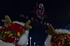 Festivalgoers watch colorful drones form illuminated figures over the night sky in Harbin.