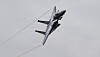 F-15E Strike Eagle flyr bratt gjennom grå himmel over Mach Loop.