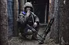 Ukrainsk soldat sitter i en skyttergrav med våpen og militært utstyr.
