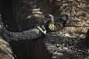 En soldat ligger hvilende i en skyttergrav dekket av jord ved frontlinjen.