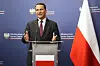 Radosław Sikorski taler ved en talerstol foran polsk flagg og blå bakgrunn med regjeringslogoer.