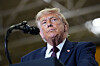 Donald Trump står ved en talerstol med mikrofoner foran seg innendørs.