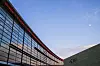 Glassfasaden på Telenors hovedkontor på Fornebu med blå himmel og en skrå bygningsdel.