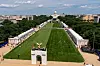 Langt utsyn over National Mall med Capitol i bakgrunnen og en stor gressplen omgitt av folk og telt.