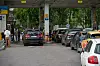 Kø av biler ved en Rosneft-bensinstasjon med flere kjøretøy under taket og ved pumpene.