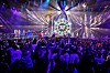 Stor Eurovision-scene med sterke lys, artister og publikum mens stemmer telles.