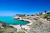 Klipper og turkist hav ved Costa Adeje på Tenerife, med en promenade langs kysten.