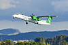 Widerøe-fly av typen Dash 8-400 stiger over landskapet etter avgang fra Sola.