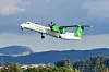 Widerøe-fly av typen Dash 8-400 stiger over landskapet etter avgang fra Sola.