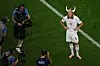 Erling Haaland står på gressbanen i hvit fotballdrakt mens kameraer og fotografer er rundt ham.