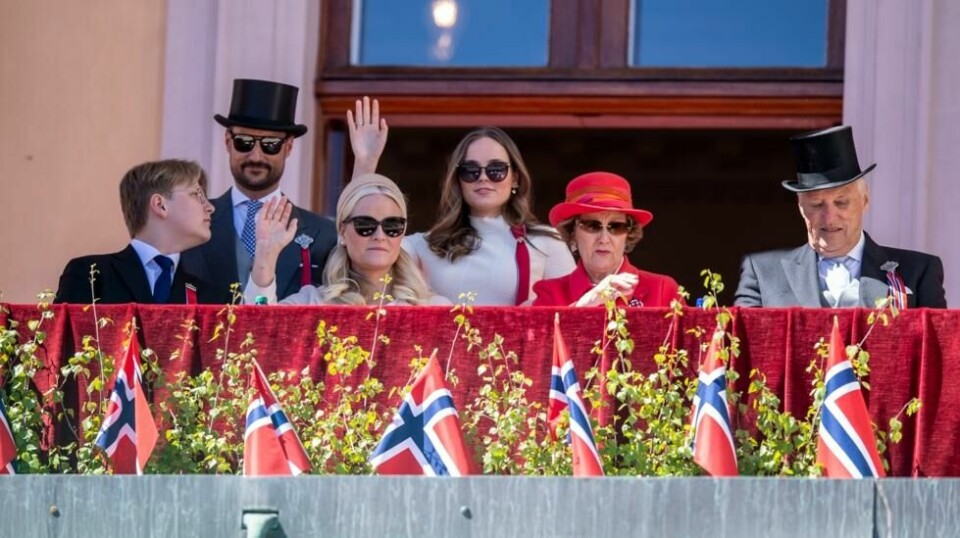 Kongefamilien vinker fra balkongen under nasjonaldagsfeiringen i Slottsparken i Oslo i 2022.