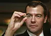 Dmitrij Medvedev holder en diamant opp mot lyset ved et sorteringssenter.