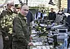 Vladimir Putin and Andrei Belousov look over military drones and equipment at a training ground.