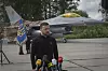 Volodymyr Zelenskyj speaks at microphones in front of an F-16 fighter jet in Ukraine.
