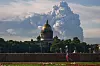 Stor røyksky over St. Petersburg med St. Isaacs katedral i forgrunnen og en person som går langs muren.