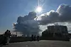 Tett røyk stiger mot himmelen over bygninger i St. Petersburg under klar himmel.