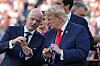 Gianni Infantino og Donald Trump undersøker medaljer før prisutdeling etter VM-finalen.