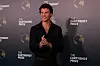 Shawn Mendes i svart antrekk poserer foran en vegg med Earthshot Prize-logoer.