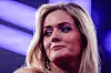 Nærbilde av en blond kvinne i lys scene-belysning med lilla toner i bakgrunnen.