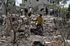 En mann rydder en skadet scooter fra sammenraste ruiner ved et ødelagt hus i Sør-Libanon.