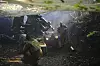 Soldater betjener en kanon i et skogsområde med røyk og trær rundt.