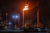 Nattbilde av et industriområde med flammer og røyk fra en Chevron-pipe.