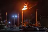 Nattbilde av et industriområde med flammer og røyk fra en Chevron-pipe.