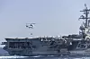 Et helikopter leverer forsyninger til hangarskipet USS Abraham Lincoln ved siden av forsyningsskipet USNS Carl Brashear.